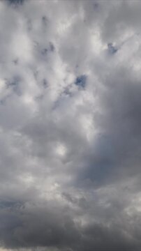 Dramatic clouds timelapse stormy sky vast turbulent layers with darker cores, fleeting light shafts, sense of approaching storm, high contrast cinematic movement