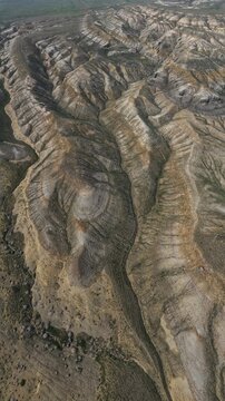 Aerial view of the vast layered rock formations and deep ridges of the arid landscape in Mangistau, Mangystau Region, Kazakhstan.