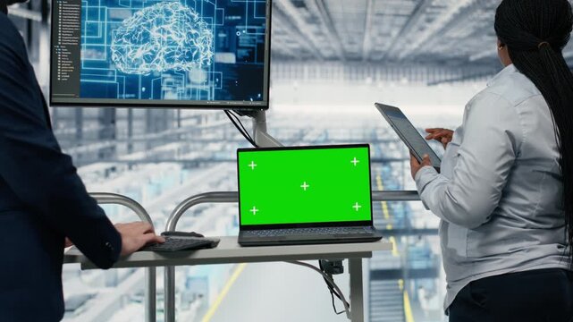 Green screen mockup laptop, using AI and businesspeople in PCB factory developing roadmap. Using neural network, chroma key notebook and directors developing semiconductor engineering tech, camera B
