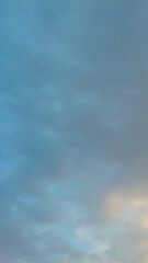 Fototapeta premium Soft blue and gray clouds fill the sky during dusk, creating a calm atmospheric background with subtle light and dramatic weather tones.