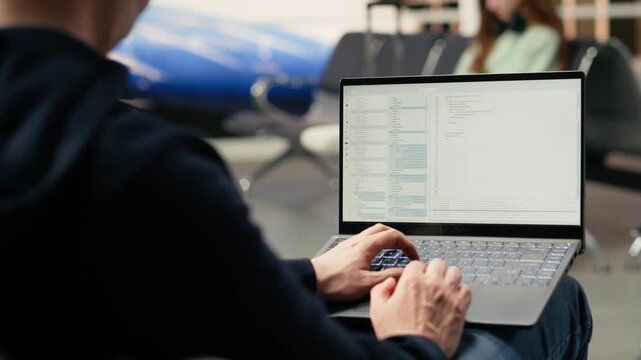 IT engineer creating scripts and managing databases for web platform while waiting for boarding in airport lounge. Emphasizes cloud computing via location independent flexible job.