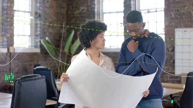 Woman shifting blueprint, man pointing with pencil, overlay appearing over plan, reviewing design