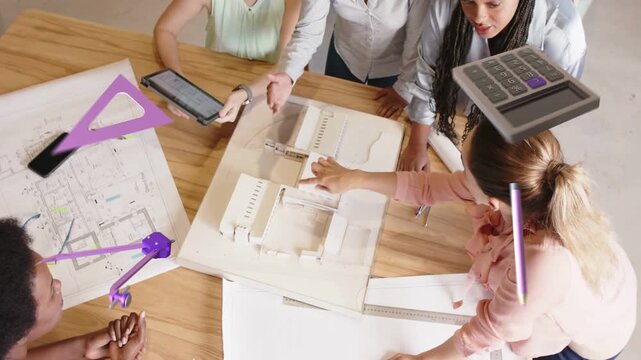 Women leaning over table pointing at model causing tablet showing design plans with motion layers