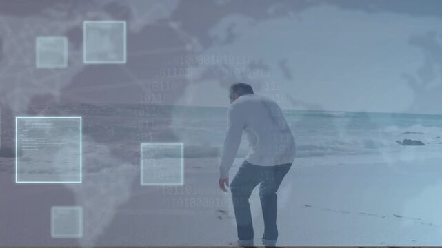 Senior man walking sandy shore, pausing, turning to sea, crouching with tech map UI squares growing