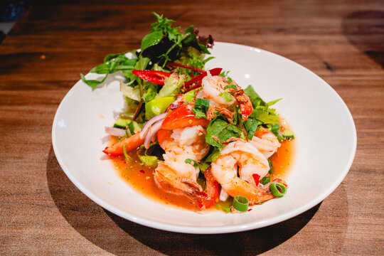 Spicy shrimp salad with herb on the white plate.