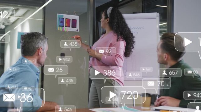Woman leading meeting pointing to mockups and writing on glass activating overlays for marketing
