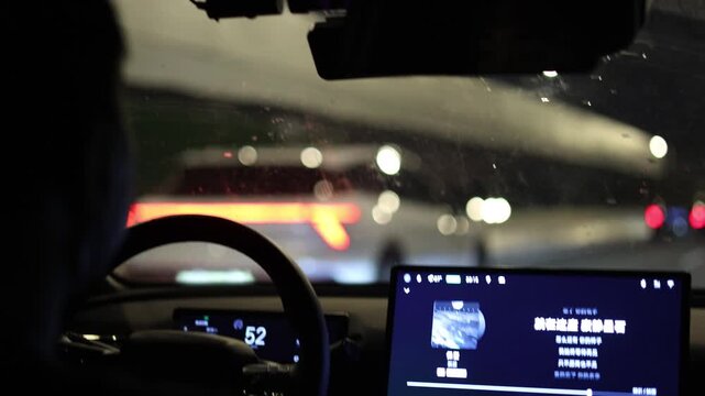 Night driving POV from inside modern car with blurred city lights traffic ahead dashboard screen illuminated Guangzhou China urban motion cinematic atmosphere