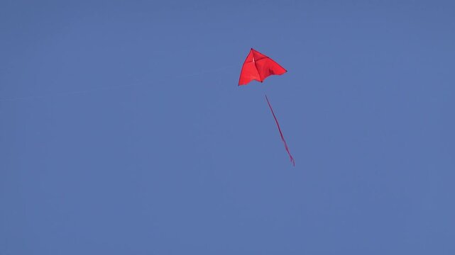 Bright red kite flying in the sky