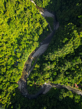 Aerial view of the winding river flowing through the dense tropical rainforest of Mount Leuser National Park Kecamatan Darul Hasanah, Aceh, Indonesia.