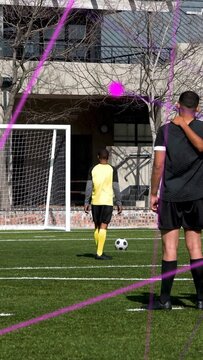 Vertical video: Soccer kicker lining ball starting runup striking and aiming at goal purple overlay