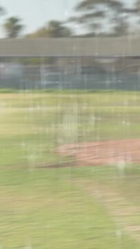 Vertical video: Baseball batter swinging on pitch, dropping bat, running for first, camera panning