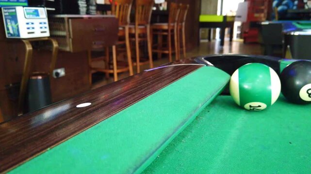 Close-up footage of American pool balls positioned near a corner pocket on a billiards table. The clip captures a tense and focused gameplay moment, ideal for themes such as competition, strategy