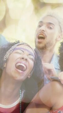 Vertical video: Two adults singing, moving at music fest, phone filming sparking cheer with bokeh