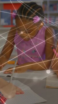 Vertical video: Students writing in class, pan revealing peers as nodes, lines drifting over table