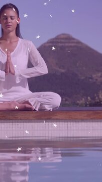 Vertical video: Female teen pressing hands, closing eyes, meditating by pool, stars drifting