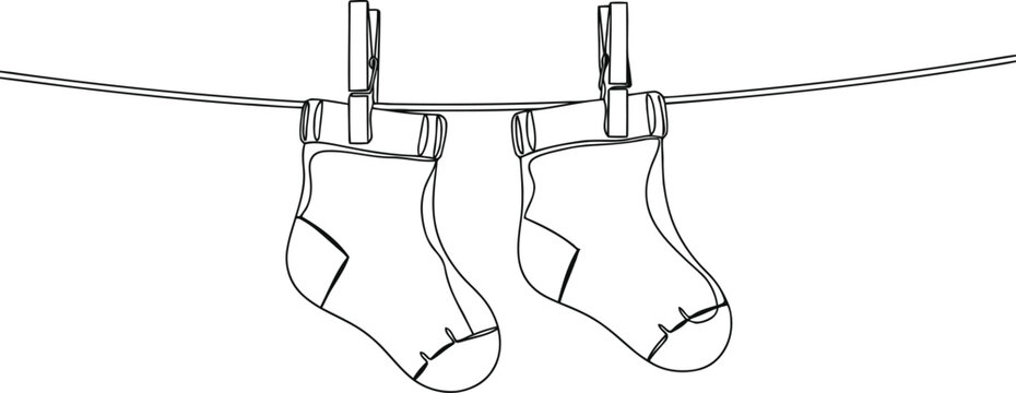 Two baby socks hanging on a clothesline with clothespins