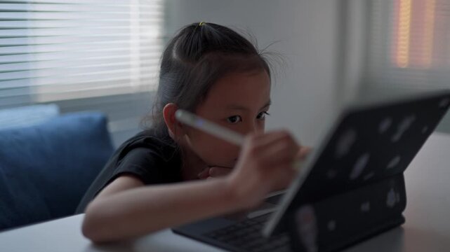 Young asian girl drawing on a digital tablet