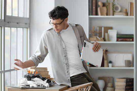 Male screenwriter using typewriter on table in office