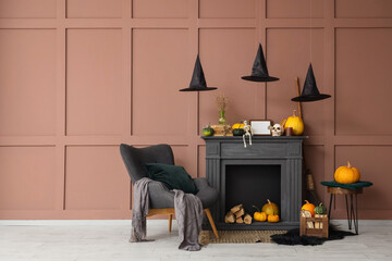 Naklejka premium Interior of living room decorated for Halloween with black fireplace, armchair and pumpkins