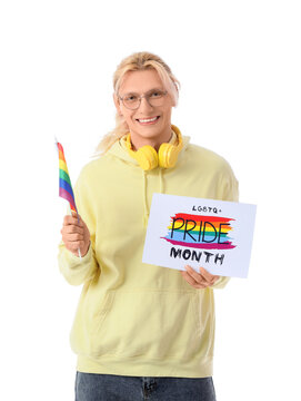 Young man holding paper with text LGBTQ PRIDE MONTH and flag on white background