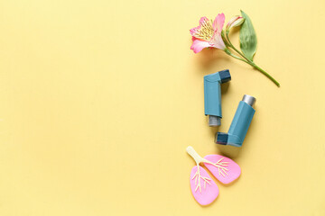 Naklejka premium Asthma inhalers with lungs figurine and alstroemeria flower on yellow grunge background