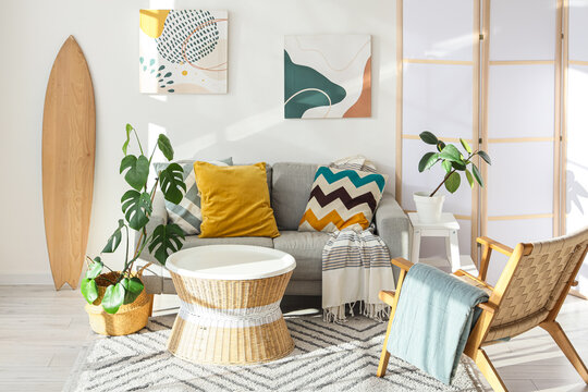 Interior of living room with surfboard, sofa and armchair