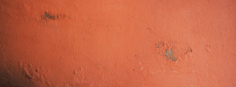 weathered orange wall with peeling paint