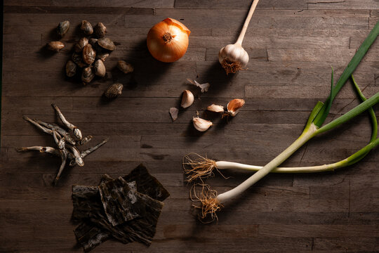 Ingredients for Korean Soup Stock with Green Onion, Onion, Garlic, Kelp, and Dried Seafood on Wooden Background