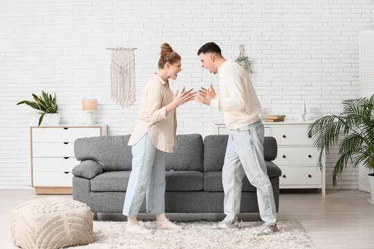 Angry young couple squabbling in living room