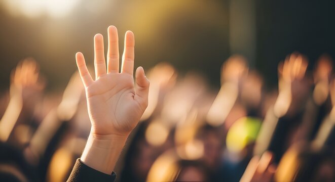 Hand raised in audience, participation, concert, event, bright lights