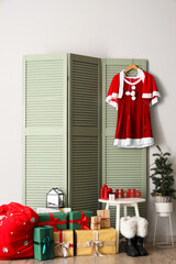 Fototapeta premium Interior of hall with Santa costume on folding screen and Christmas presents