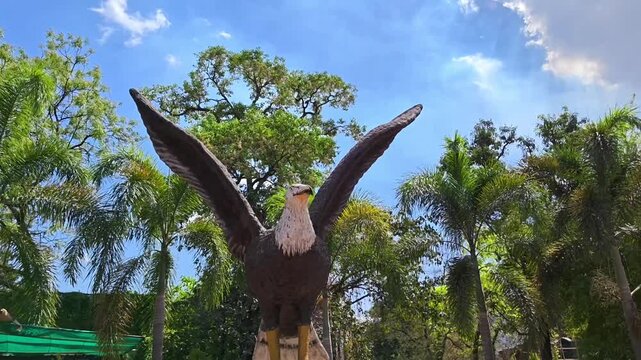 Majestic bald eagle statue with outstretched wings in tropical park