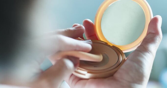 Woman applying powder with a puff from a compact case, soft lighting, beauty and skincare routine concept, minimal and elegant daily makeup moment, Close-up