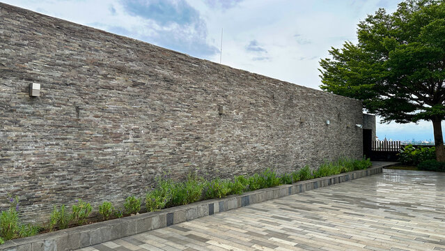 Luxury Stone Cladding Building Exterior Wall with Landscaped Planter, Paved Courtyard and City Skyline &mdash; Urban Architecture
