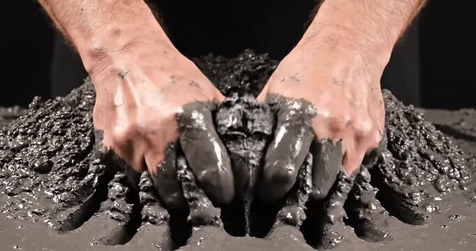 Hands manipulating wet concrete in a creative process, showcasing texture and technique