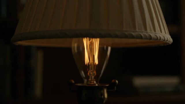 Soft, warm ambient lighting from a pleated decorative lamp illuminating a cozy interior space.