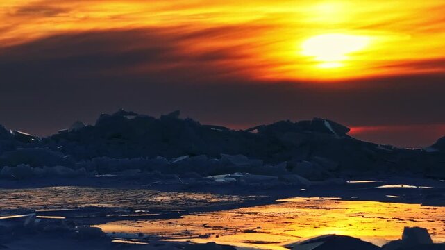 Frozen arctic ocean reflecting dramatic sunset colors with ice formations