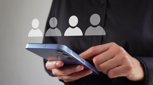 Businesswoman holding a smartphone with an animated row of avatars, one of whom stands out. This indicates the correct personnel selection.