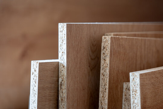 Stack of chipboard panels in carpentry workshop, particle board sheets detail, wood material for furniture production, construction industry background