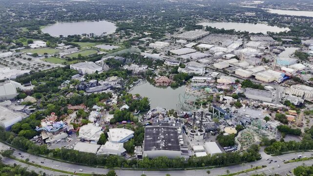 Aerial view of Universal Orlando theme park with lake, roller coasters and cityscape, Florida USA. g.