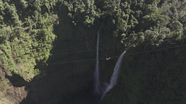 Thrilling zipline experience over Tad Fane twin waterfalls in Bolaven Plateau, Laos - Aerial drone shot ( HLG log )
