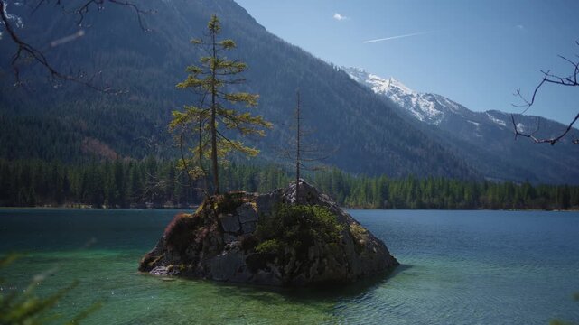 Crystal clear water of the Hintersee lake in Ramsau with alpine mountain peaks in the sun, Bavaria