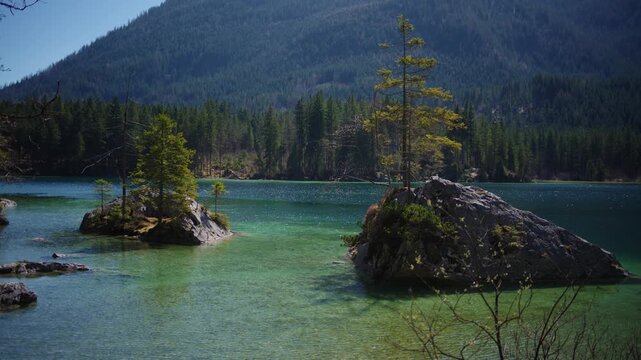 Hintersee mountain lake with rocky islands surrounded by green forest, Berchtesgaden. Turquoise water
