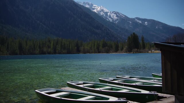 Wooden boats at the pier of Lake Hintersee, a turquoise mountain lake in Berchtesgaden, Bavaria.