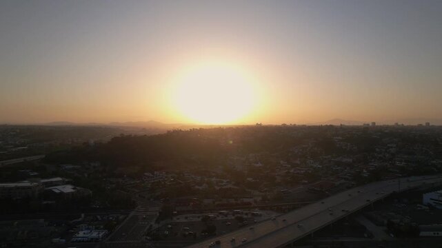 Drone flying toward the Hillcrest and North Park areas of San Diego at 6AM capturing early morning light and city layout.