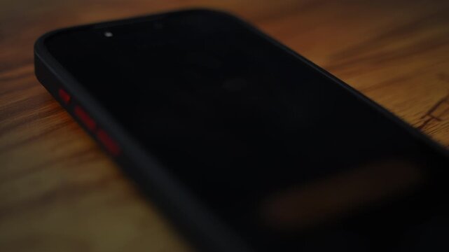 Smartphone alarm clock showing 6:00 on screen. morning wake up concept with mobile phone in dark room