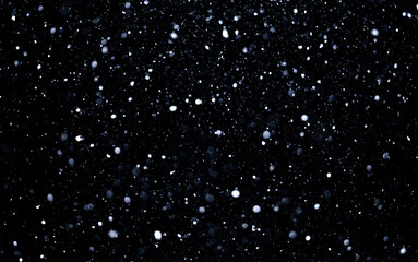 Snow particles drifting across black winter background. Snow overlay effect with falling...