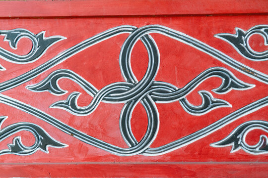 Traditional ornamental pattern with red and black ethnic motif inspired by Indonesian cultural art design.