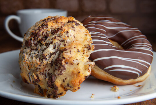 Reposteria fina, pan dulce mexicano para desayuno postres o cenas en familia, tradicional. Acercamiento o macro con pan cubierto con chocolate almendra y coco con taza de cafe al fondo.