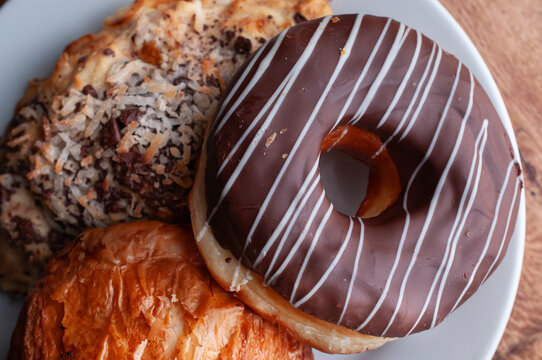 Reposteria fina, pan dulce mexicano para desayuno postres o cenas en familia, tradicional. Dona cubierta de chocolate sobre plato blanco vista cenital o lay flat.